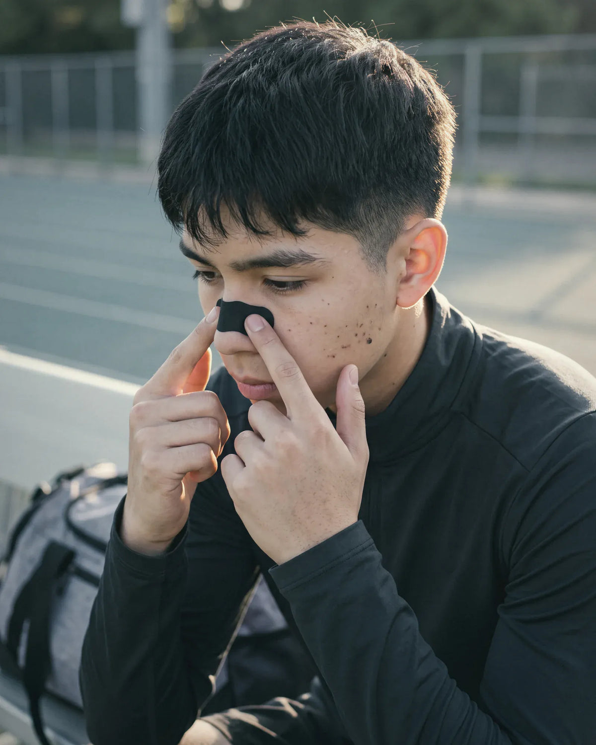 Athlete pressing a nasal strip into place