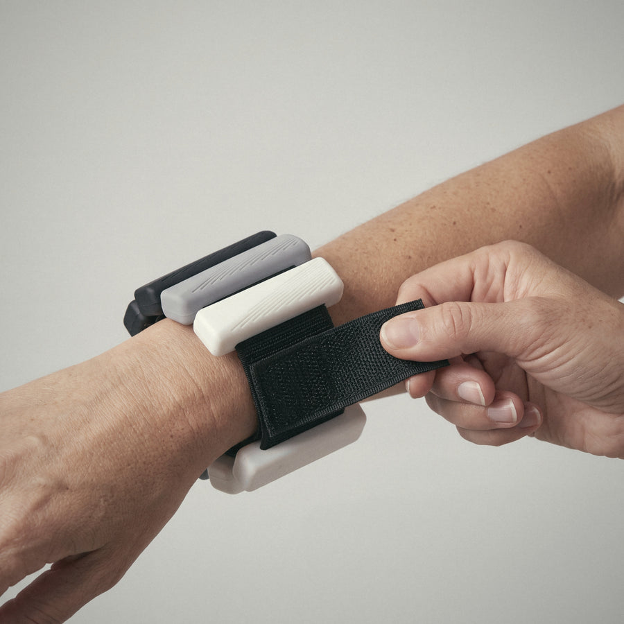 Hand fastening an OXYFIT Wearable Weights strap on the wrist